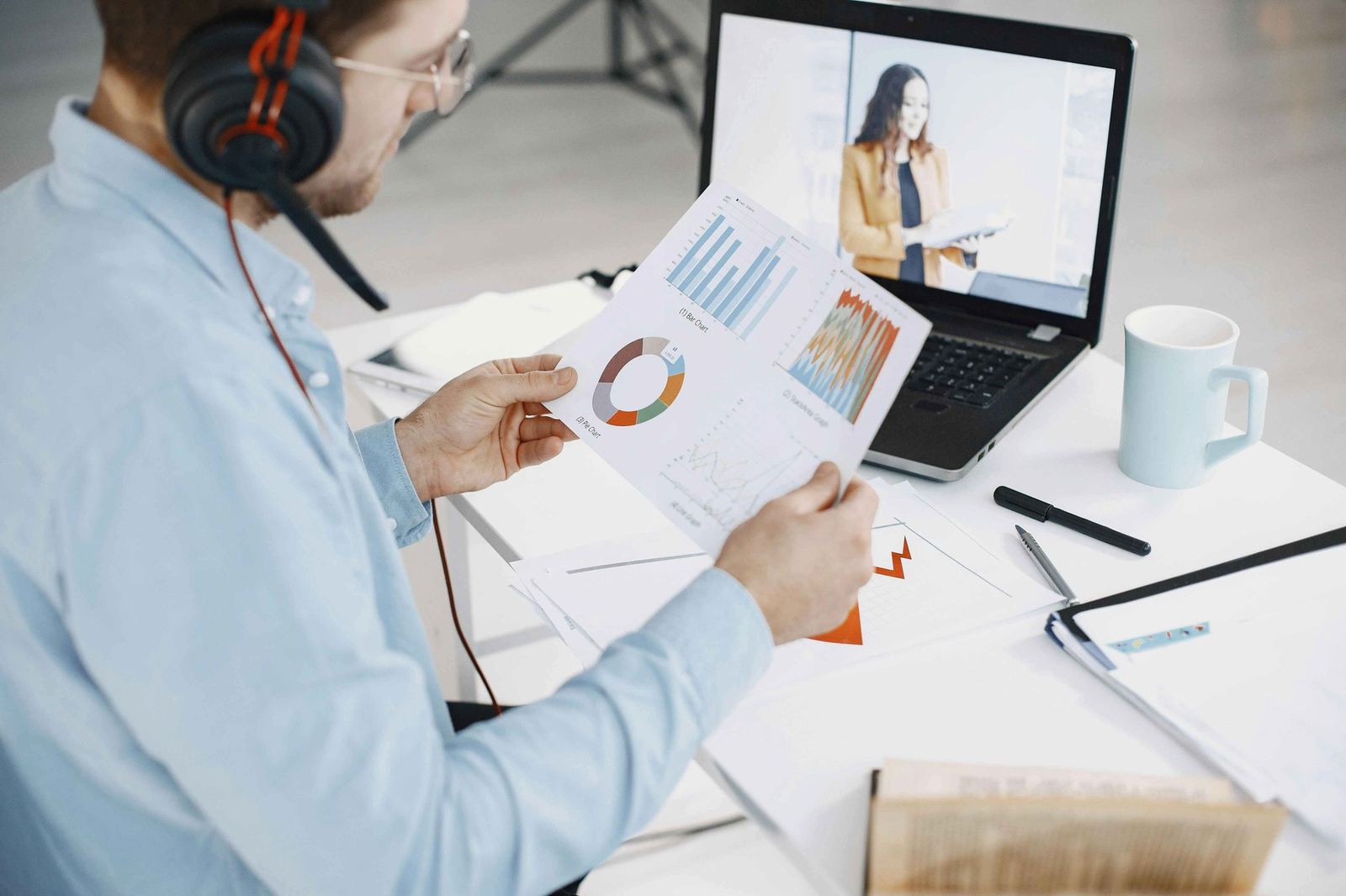 man-holding-video-analytics-with-video-playing-on-laptop